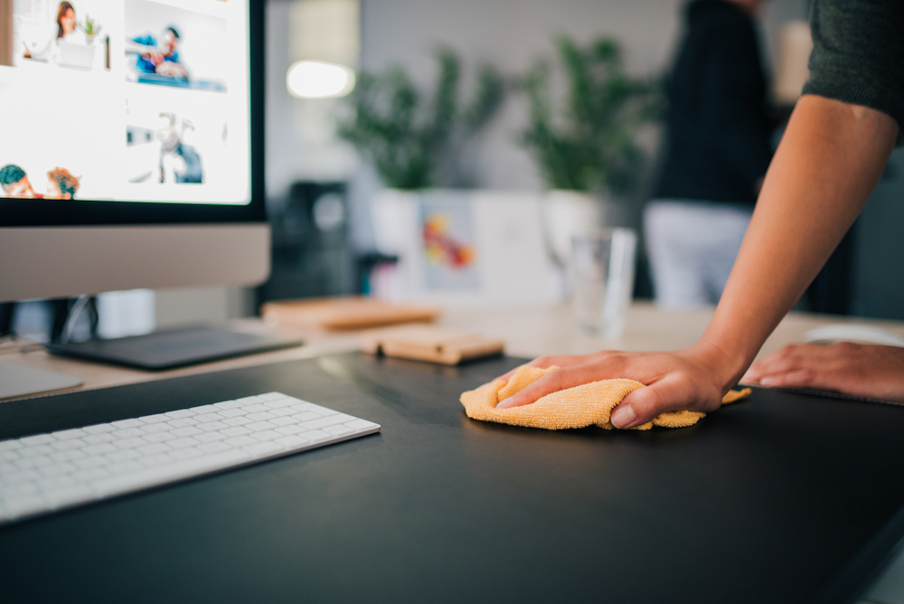 Hand,Of,A,Woman,Wiping,Work,Desk,,Close-up.
