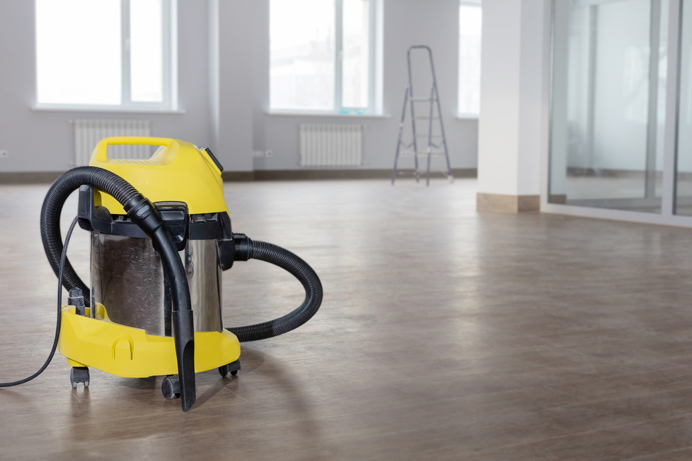 Yellow,Vacuum,Cleaner,On,The,Wooden,Floor,Against,The,Background
